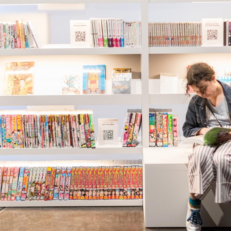 A young visitor reading in the Manga exhibition at the Community Preview, British Museum