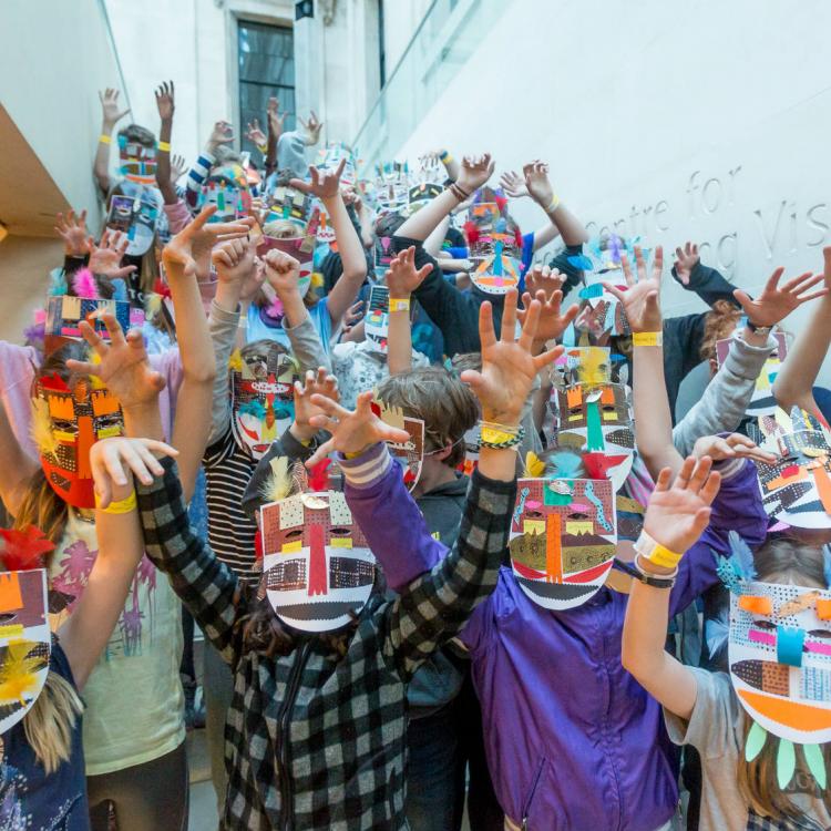 A big group of children at a Museum sleepover wearing masks they made themselves