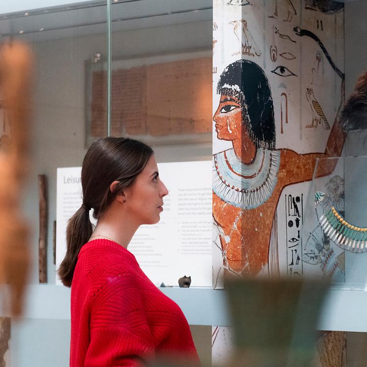 A woman looking at the display of fashion items from ancient Egyptian life in Room 61