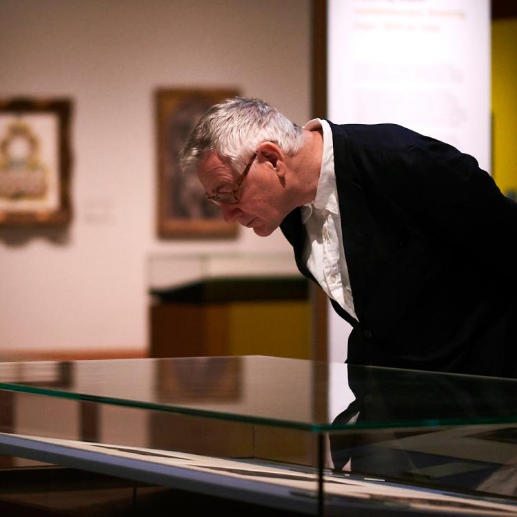 A visitor looking at the artwork on display in Prints and Drawings