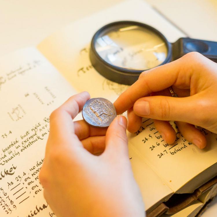 A coin, magnifying glass and book