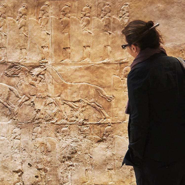 Visitor looking at Neo-Assyrian relief sculpture