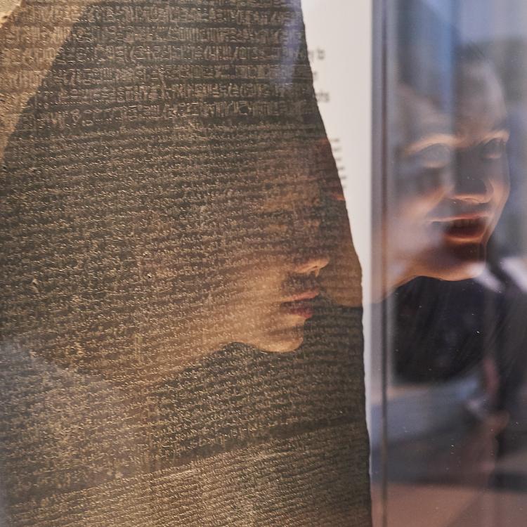 Visitors examining the Rosetta Stone in the Egyptian Sculpture gallery