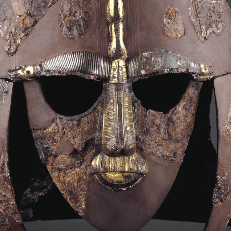 Iron and tinned bronze helmet with gold features, looking face on. 