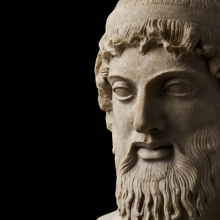 Marble head from a statue of Bacchus, who has a beard and long hair.