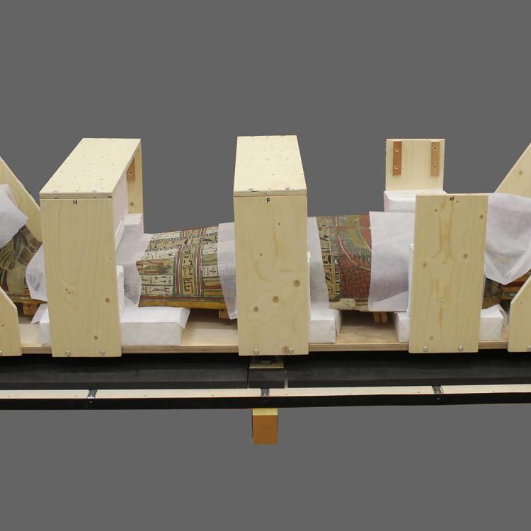 A mummy encased in layers of a supportive crate ready for transportation.