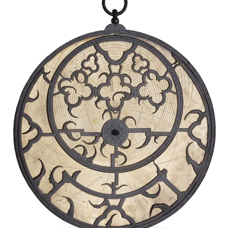 A cream astrolabe with dark-grey metal work.