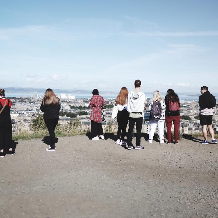 Group of young people looking out to Edinburgh city and sea.