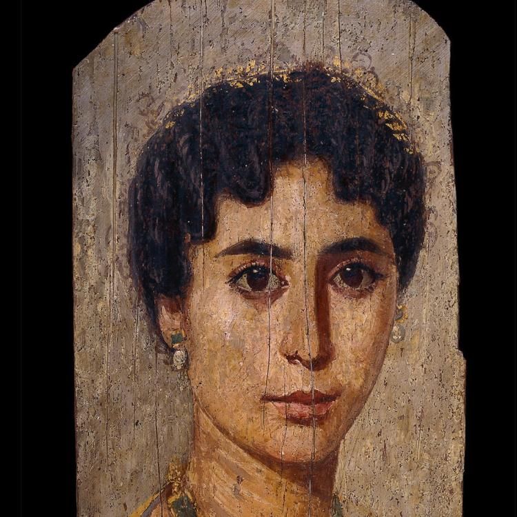 Detail of a mummy portrait of a woman, wearing a jewel encrusted necklace and a diadem, with black curly hair.