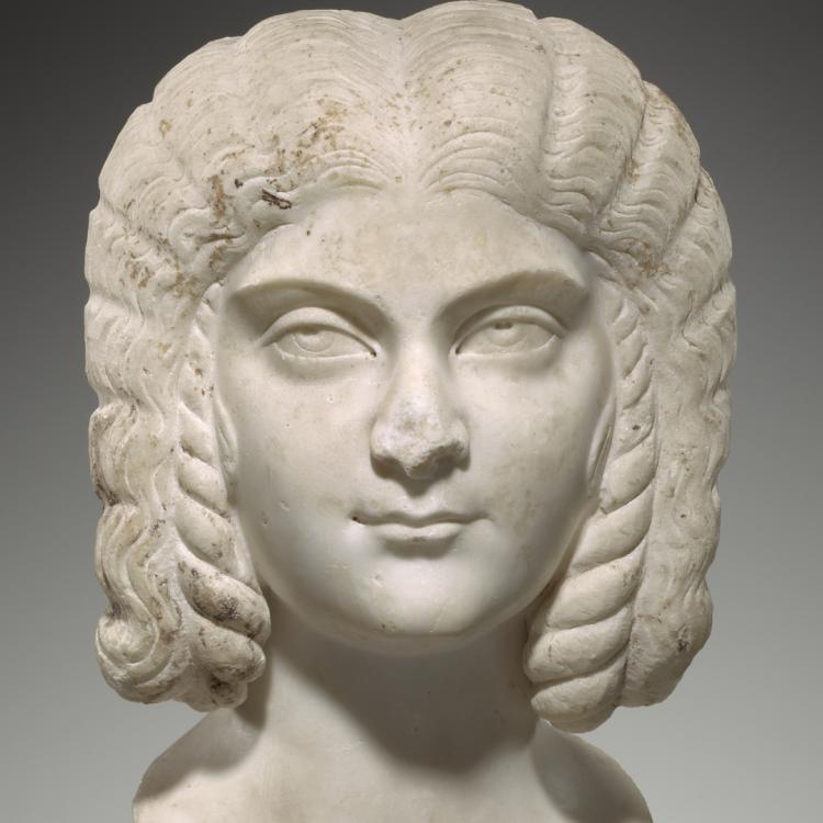 A white marble portrait of a woman with centre parting and braided wig.