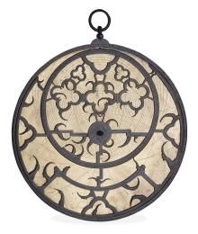 A cream astrolabe with dark-grey metal work.