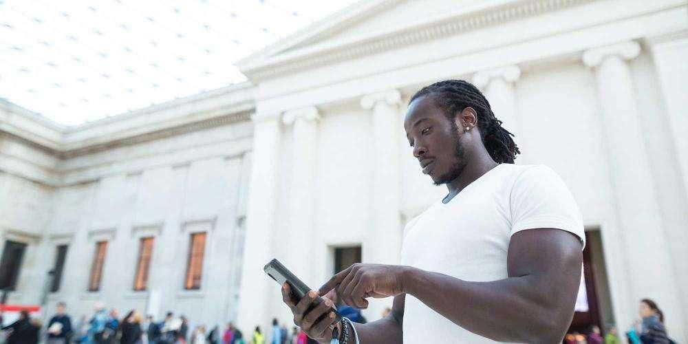 A man uses the audio guide in the Great Court 