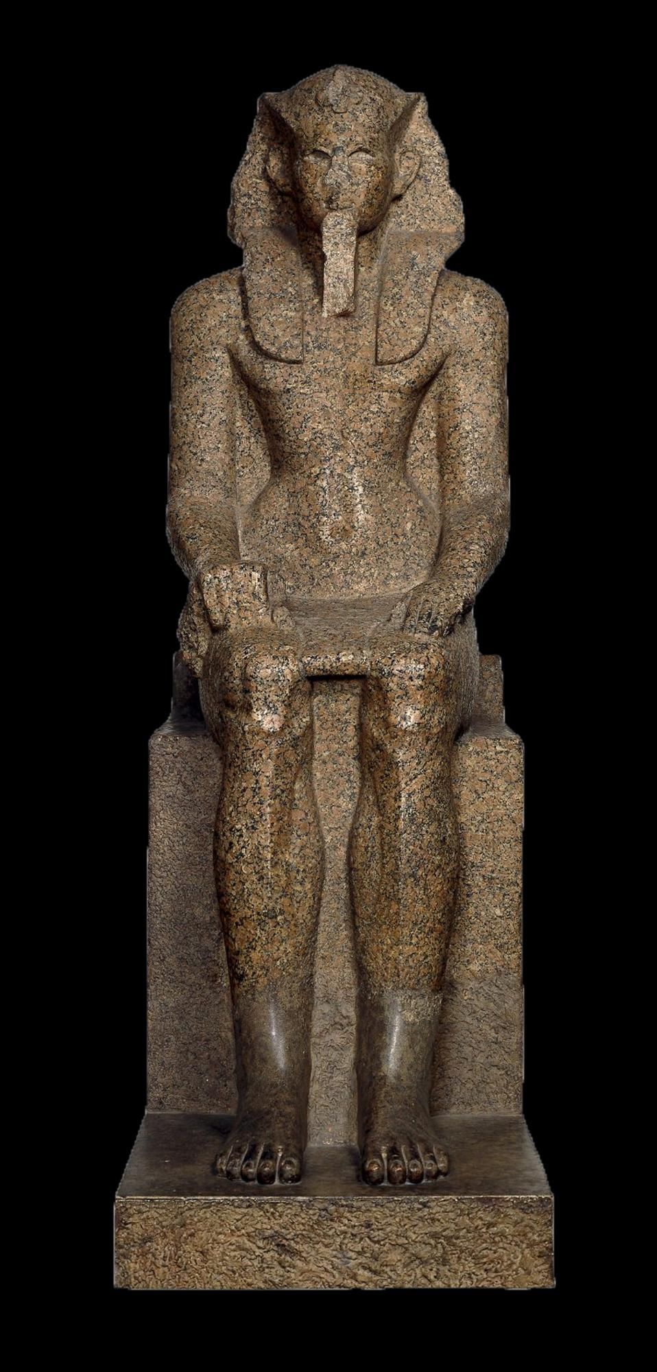 Large, sitting down Pharaoh sculpture hands on lap.