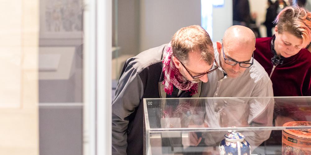 A group looking closely at objects at community preview, British Museum