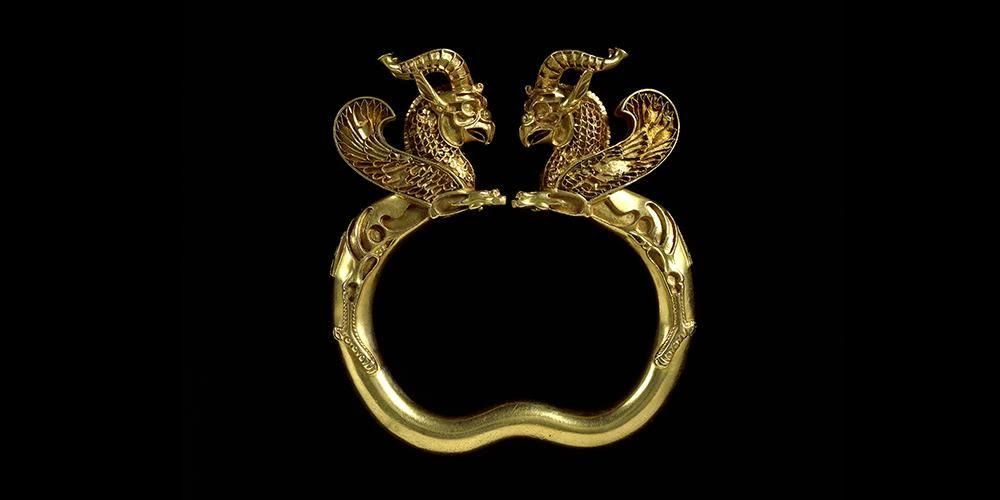 Gold armlet with two dragon looking figures attached. 