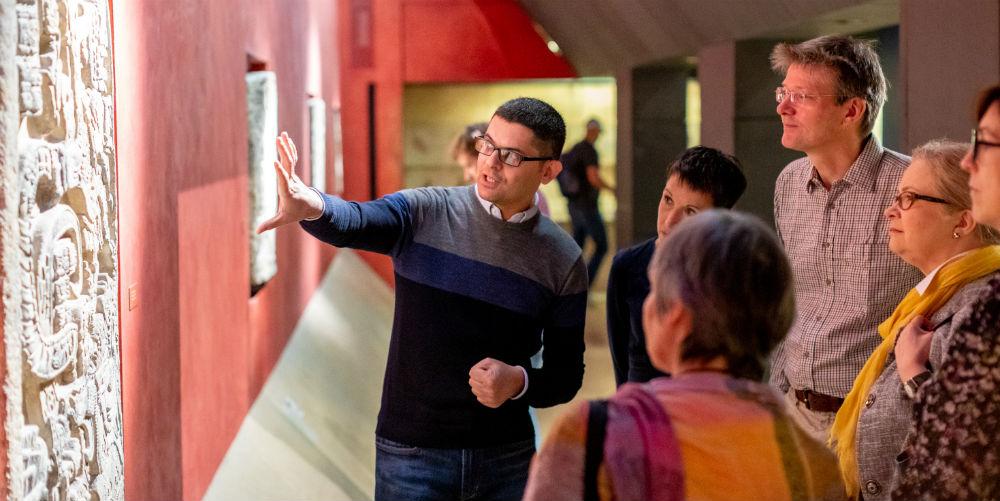 Volunteer explaining object to a group of Museum visitors