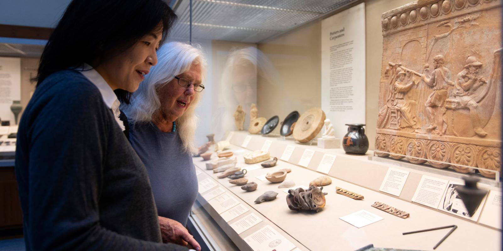 Two female visitors looking at the objects on display in Room 69