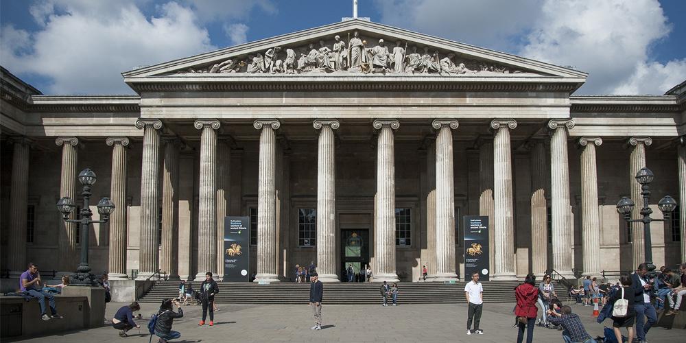 Visitors outside the British Museum entrance, which is a Greek revival style building.