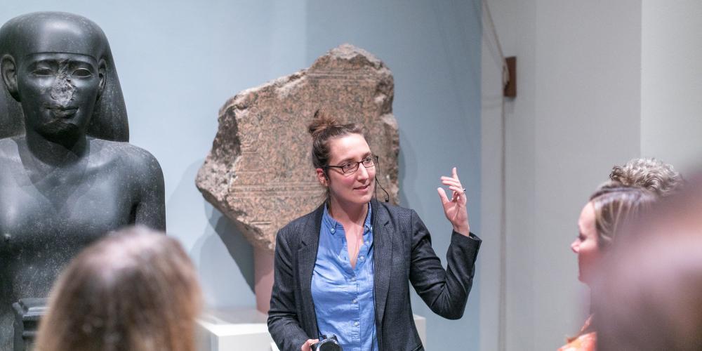 A British Museum tour guide speaking to visitors.