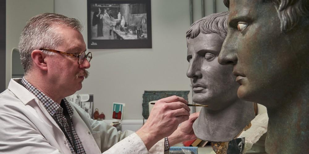 A man creating a copy of a sculpture of a head