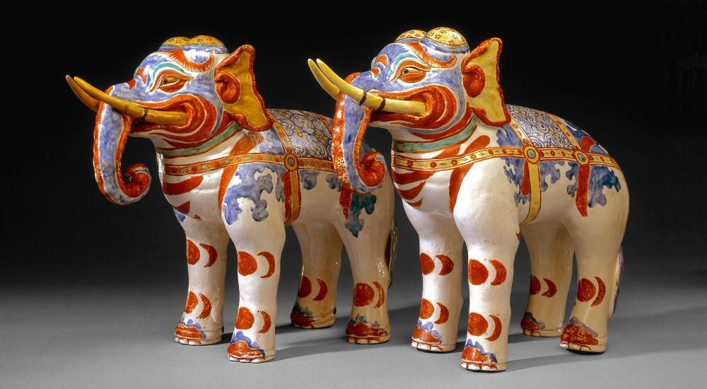 Two red, white, blue and gold decorated mantelpiece elephants figures.