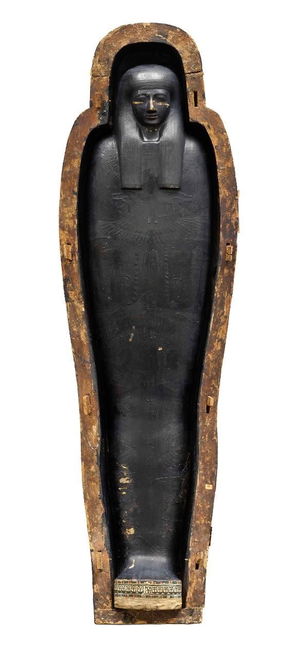 Overhead view of mummy encased in cartonnage in open wooden coffin