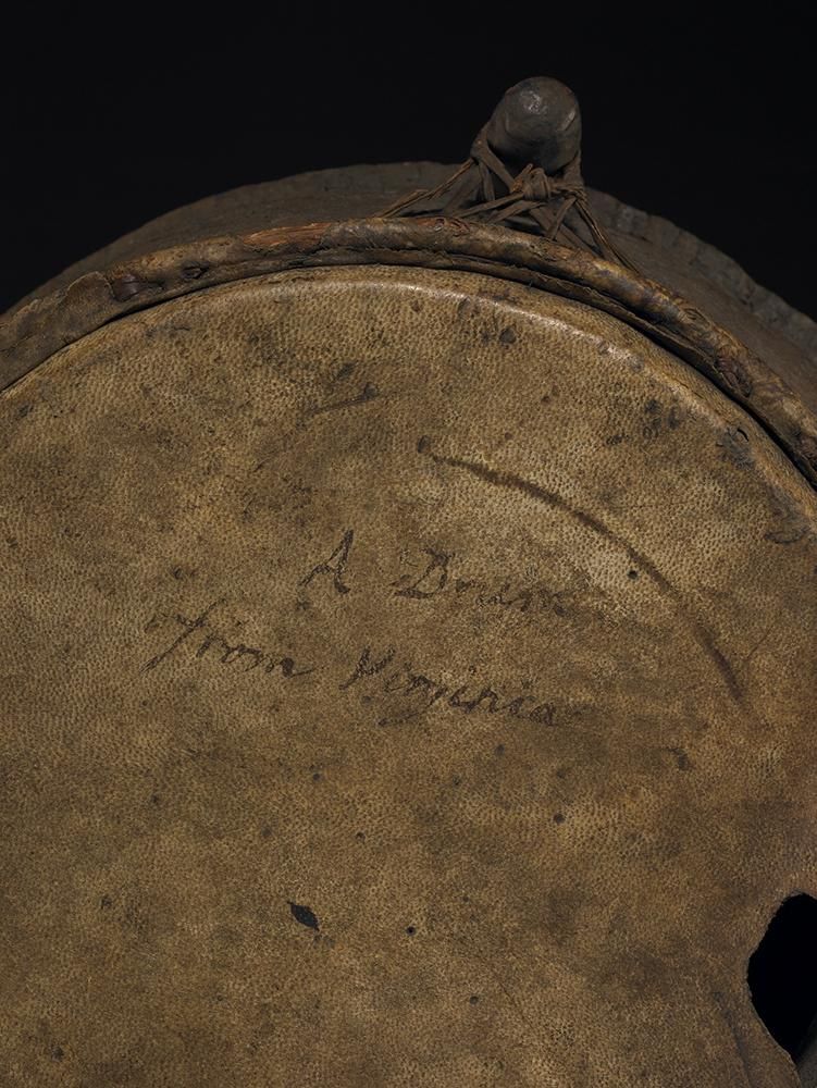 Close up of the top of a drum with a note saying 'A Drum from Virginia' written on the drum skin.