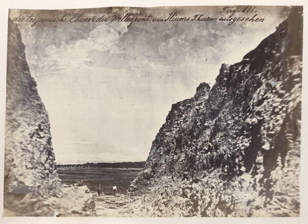 Photo looking through trench where people are standing, handwriting at the top