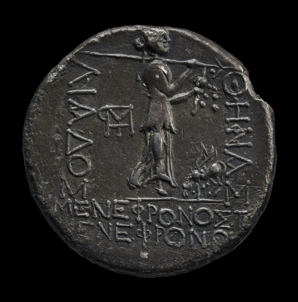 Silver coin showing standing figure in profile and inscription, visible wear around edges