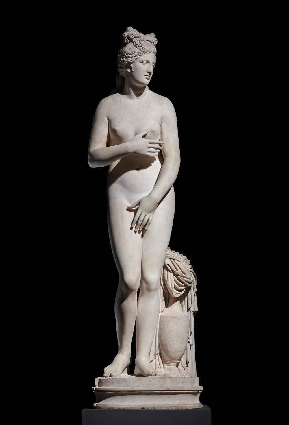 A marble statue of Aphrodite, standing with her hands covering her breasts and genitalia.