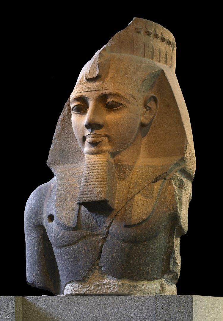 Head and upper body of pink/grey granite monumental statue of Ramesses II