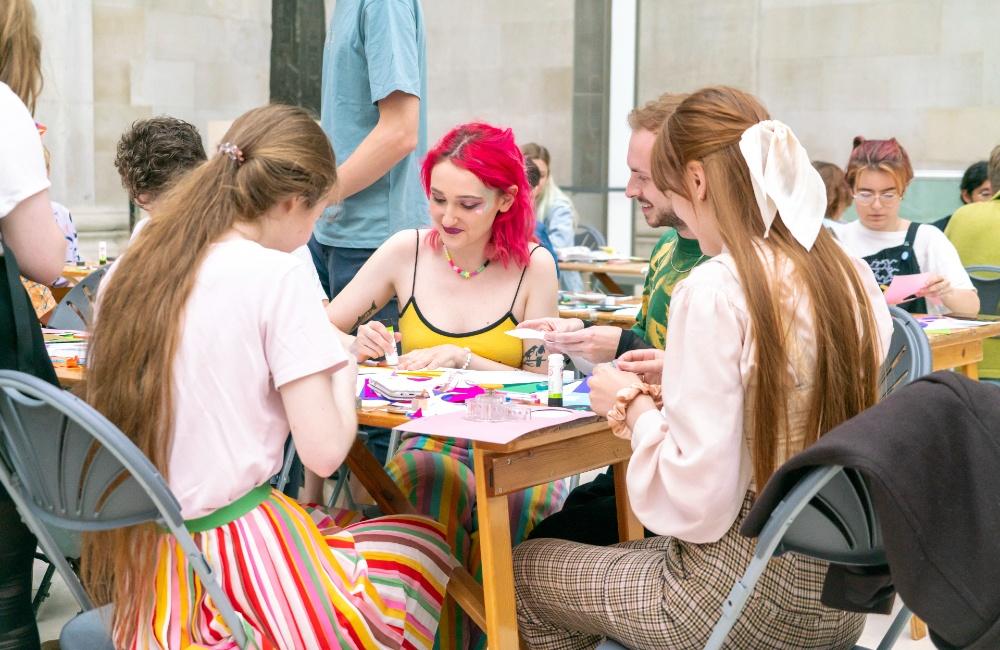 Visitors seated around a table, taking part in the activities. 