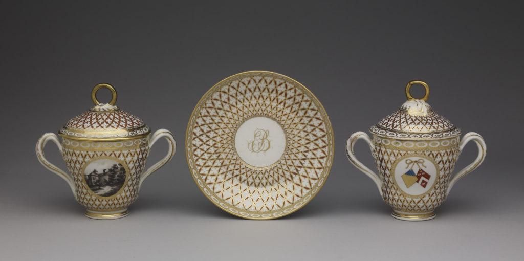 Pair of chocolate-cups, covers and saucers with twisted handles and gold patterned design