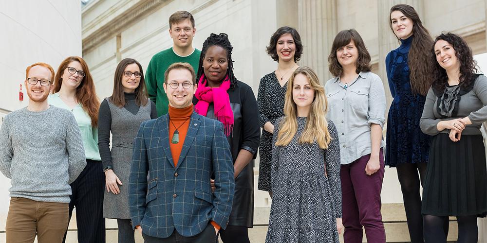 A group of research students on the stairs in the Great Court.