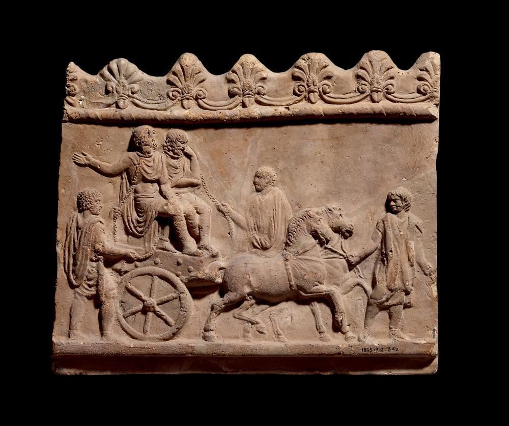  Terracotta slab with a carving showing two distressed people on a horse-led cart in chains, while other people in tunics attend to the cart and horses